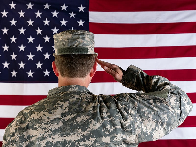 soldier saluting in front of flag
