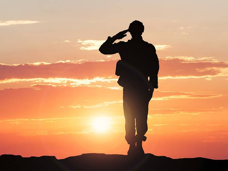 A brandingArc silhouette of a soldier saluting at sunset.