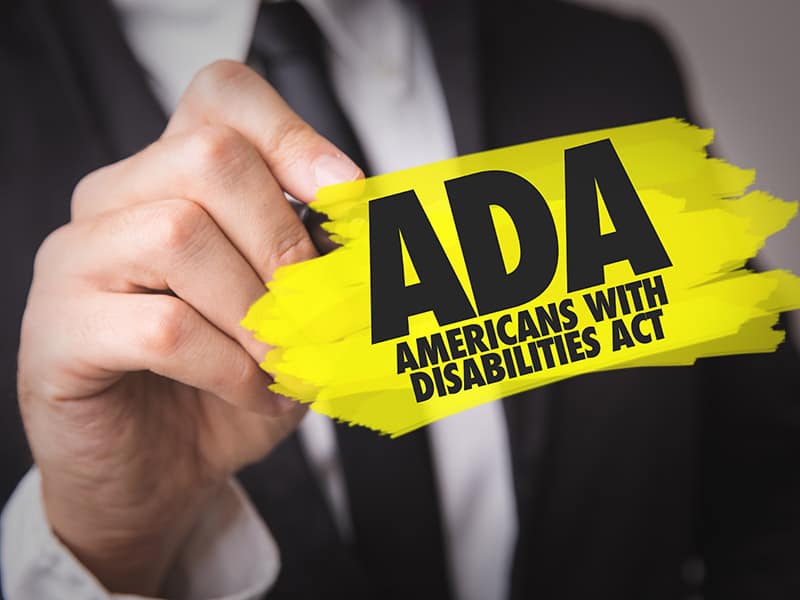 A man holding up a sign that says americans with disabilities act.