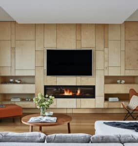A modern living room with a fireplace, tv, and brandingArc.