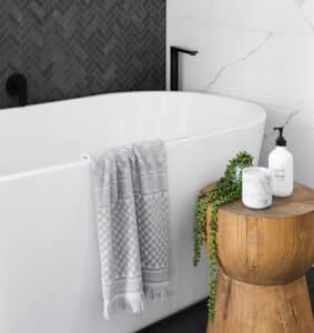A black and white bathroom with a wooden stool, showcasing the brandingArc aesthetic.
