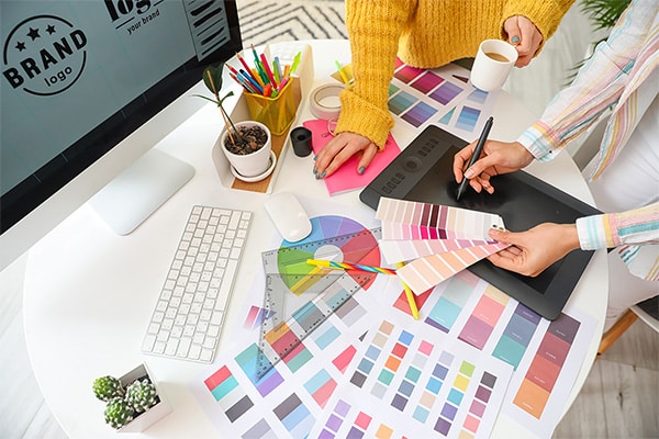 A group of people working on a desk with color swatches, focusing on marketing strategies.