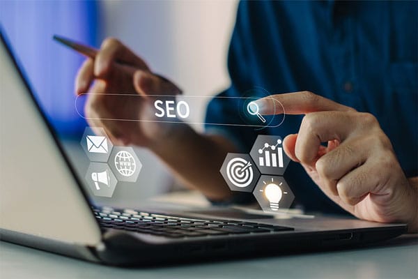 A person using a laptop with overlay icons representing SEO, analytics, and digital marketing.